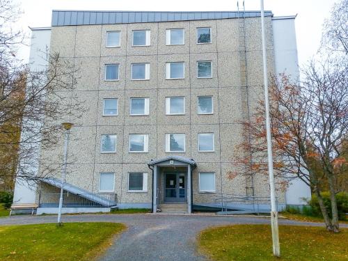 un gran edificio de ladrillo con una escalera delante de él en Apartment Kukkarokivenkatu, en Mänttä