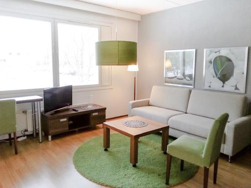 een woonkamer met een bank en een tafel bij Apartment Kukkarokivenkatu in Mänttä
