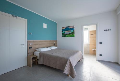 a bedroom with a bed and a blue wall at La Guest House di PIAZZA MOTTA in Albese Con Cassano
