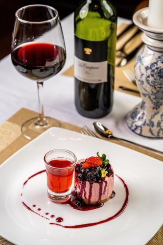 a plate with a dessert and a glass of wine at Summerhill Bungalow by Bluechip Leisure in Nuwara Eliya
