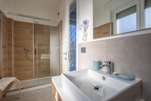 a bathroom with a sink and a shower at La Guest House di PIAZZA MOTTA in Albese Con Cassano