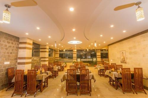 a restaurant with tables and chairs in a room at Dharamshala Paradise Sheela in Dharmsala
