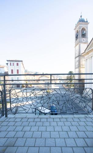 a metal sculpture in front of a building with a clock tower at La Guest House di PIAZZA MOTTA in Albese Con Cassano