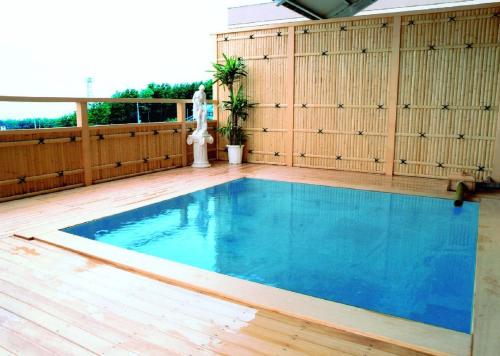 a large swimming pool on a wooden deck with a wooden at Hotel Tetora Resort Tsuruoka in Tsuruoka