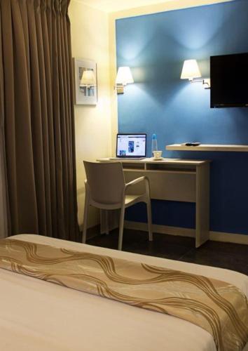 a hotel room with a desk and a laptop computer at Pillows Hotel Cebu in Cebu City