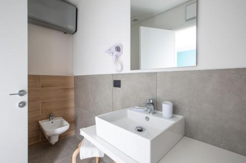 a bathroom with a white sink and a toilet at La Guest House di PIAZZA MOTTA in Albese Con Cassano