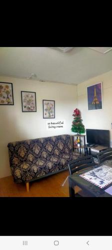 a living room with a couch and a christmas tree at Two-Bedroom at San Remo Oasis in Cebu City