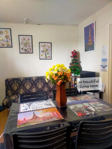 a table with a vase of flowers on top of it at Two-Bedroom at San Remo Oasis in Cebu City