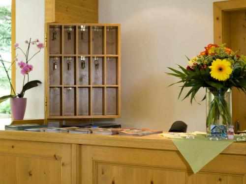 a counter with a vase of flowers on it at Landgasthof Lusenblick in Grafenau