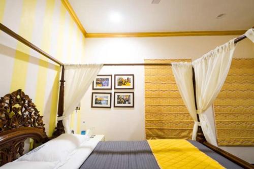 a bedroom with a canopy bed with a yellow blanket at The Corner Courtyard in Kolkata