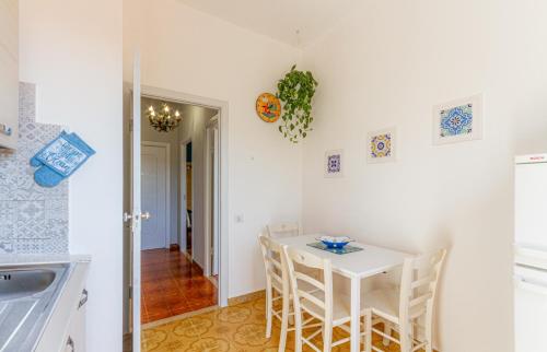 a small kitchen with a white table and chairs at Carloforte Appartamento con Vista IUN R2015 in Carloforte