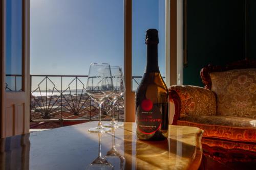 a bottle of wine on a table with two wine glasses at Carloforte Appartamento con Vista IUN R2015 in Carloforte