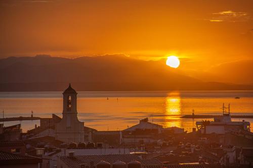 a sunset over a city with a clock tower at Carloforte Appartamento con Vista IUN R2015 in Carloforte
