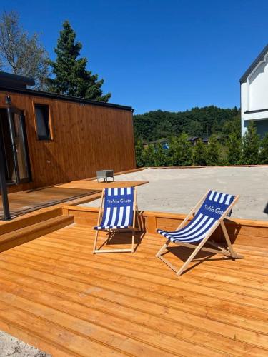 two blue and white chairs sitting on a wooden deck at Dzika Łąka in Nowęcin