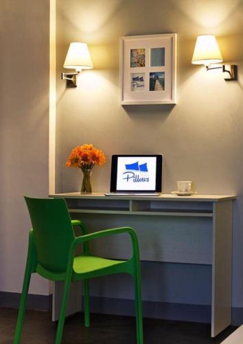 a desk with a green chair and a laptop on it at Pillows Hotel Cebu in Cebu City