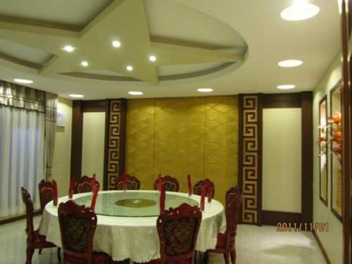a dining room with a round table and chairs at Great Wall Hotel in Dar es Salaam