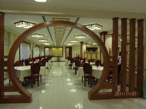 a dining room with tables and chairs and a large mirror at Great Wall Hotel in Dar es Salaam