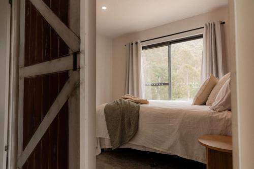 un dormitorio con una cama y una ventana en The Wilds, en Four Mile Creek