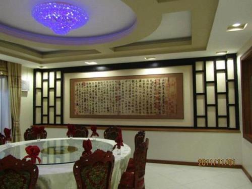 a dining room with a table and chairs and a painting at Great Wall Hotel in Dar es Salaam