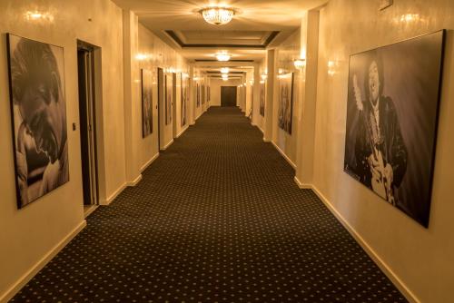 a long hallway with paintings on the walls at Casino Motel Senator in Gevgelija