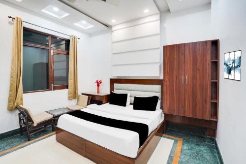 a bedroom with a bed and a desk and a window at Super Townhouse Selaqui Chakrata Road in Dehradun