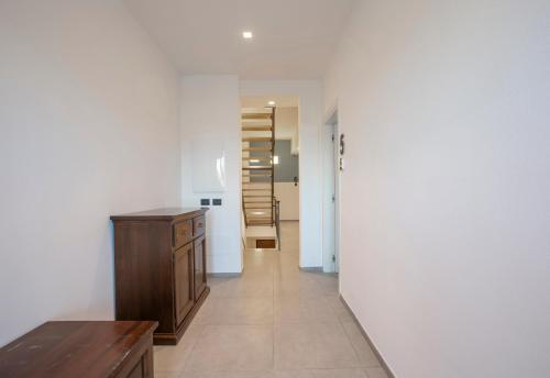 a hallway with a wooden table and a stair case at La Guest House di PIAZZA MOTTA in Albese Con Cassano