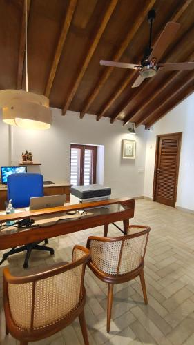 a dining room with a table with chairs and a laptop at Rosastays Panjim North Goa in Goa