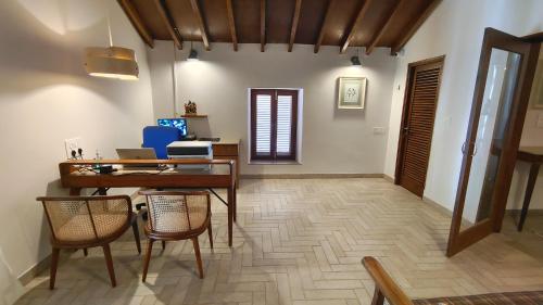 a living room with a table and chairs and a desk at Rosastays Panjim North Goa in Goa