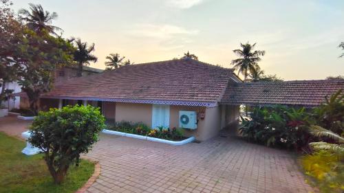 a house with a tiled roof and a courtyard at Rosastays Panjim North Goa in Goa