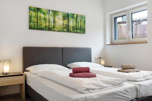 two beds in a bedroom with a painting on the wall at Mohnblume in Unterwittighausen