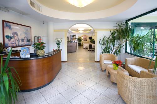 a hotel lobby with a reception desk and chairs at Hotel Boccaccio-free parking- in Milano Marittima