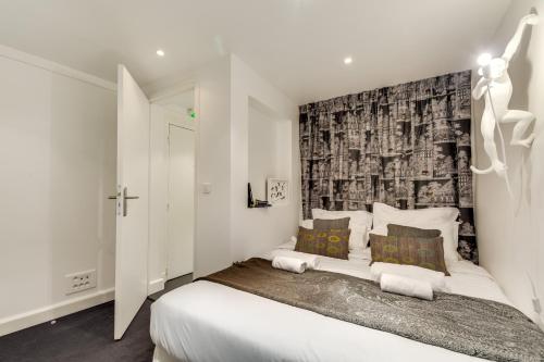 パリにあるSweet Inn - Etienne Marcelのベッドルーム1室(壁に白い大型ベッド1台付)