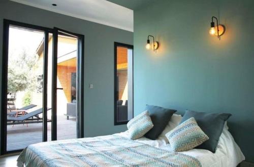 - une chambre avec des murs bleus et un lit avec des oreillers dans l'établissement Ecological wooden house Saint Remy de Provence, à Saint-Rémy-de-Provence