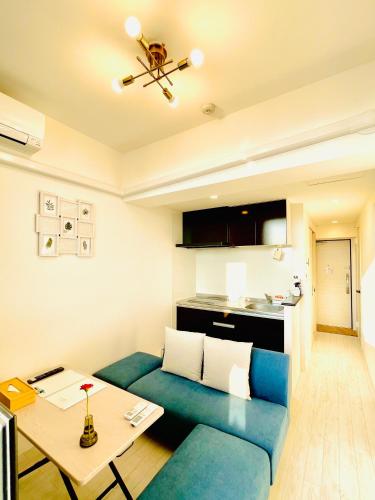 a living room with a blue couch and a table at CRYSTAL & RESORT Exclusive in Fukuoka