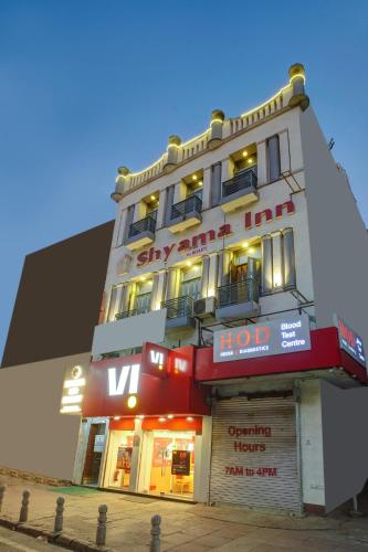 a tall white building with a sign on it at Shyama inn by Rivlet in New Delhi