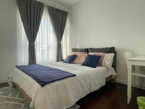 a bedroom with a large bed with blue pillows at Baan Sandao Condo Hua Hin in Hua Hin