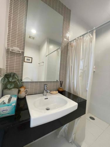 a bathroom with a white sink and a mirror at Baan Sandao Condo Hua Hin in Hua Hin