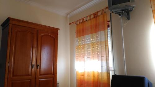 a room with a wooden cabinet and a window at Pousada Farol do Portinho in Vila Praia de Âncora