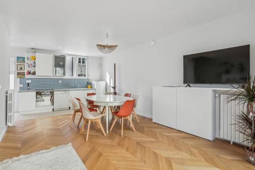 une cuisine et une salle à manger avec une table et des chaises dans l'établissement Family home, à Romainville