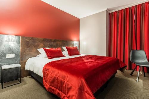 a hotel room with a red bed and a chair at Martin's Brussels EU in Brussels