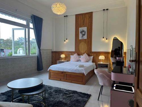 ein Schlafzimmer mit einem Bett, einem Tisch und einer Couch in der Unterkunft Thái Bảo Châu PHT - Homestay in Khu Chi Lăng