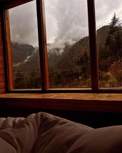 a bedroom window with a view of a mountain view at Ch'i Soulstone HomeStay in Sainj