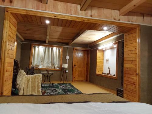 a bedroom with a bed in a room with wooden walls at Ch'i Soulstone HomeStay in Sainj