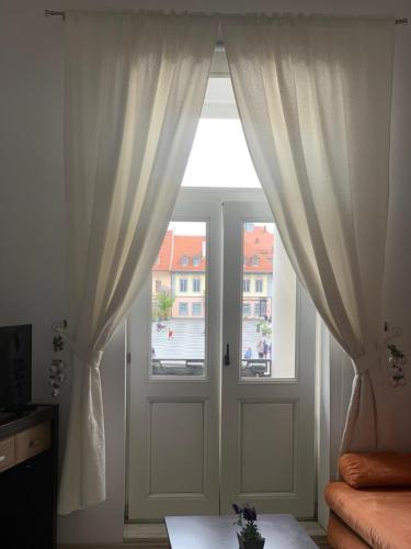 a room with a door and a window with curtains at View of Main Square Studio in Sibiu