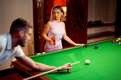 a man and a woman playing a game of pool at Summerhill Bungalow by Bluechip Leisure in Nuwara Eliya