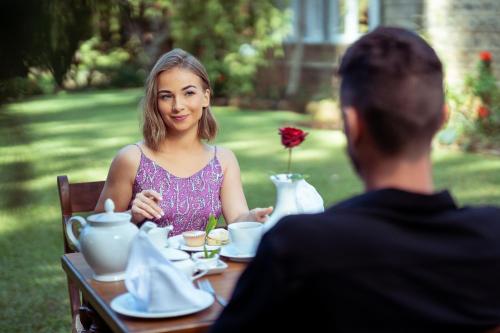 a woman sitting at a table with a man at Summerhill Bungalow by Bluechip Leisure in Nuwara Eliya