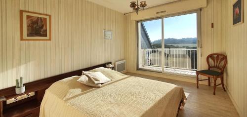 une chambre avec un lit et une grande fenêtre dans l'établissement Vue Ciel et Mer chez Ginette, à Quiberon