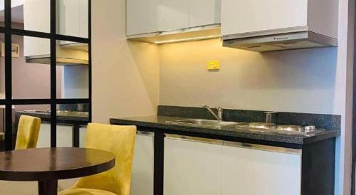 a kitchen with a counter and a table and a sink at Lancaster Hotel Manila in Manila