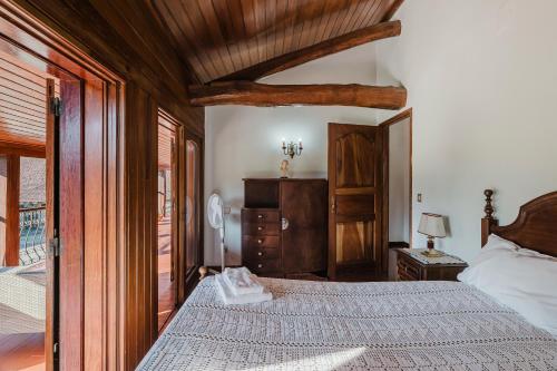 a bedroom with a large bed and a wooden ceiling at Quinta Das Regadas in Rendufe