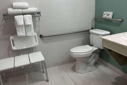 a bathroom with a toilet and a sink and towels at Wingate by Wyndham Sioux City in Sioux City